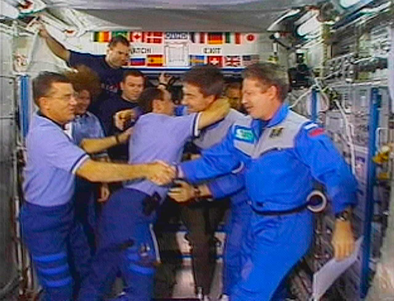 People are seen shaking hands and hugging.