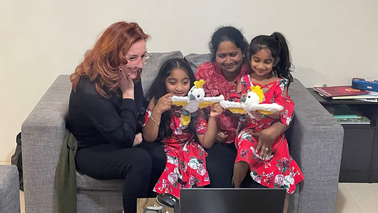Rebekah Holt with Priya, Kopika and Tharnicaa sitting on a couch.