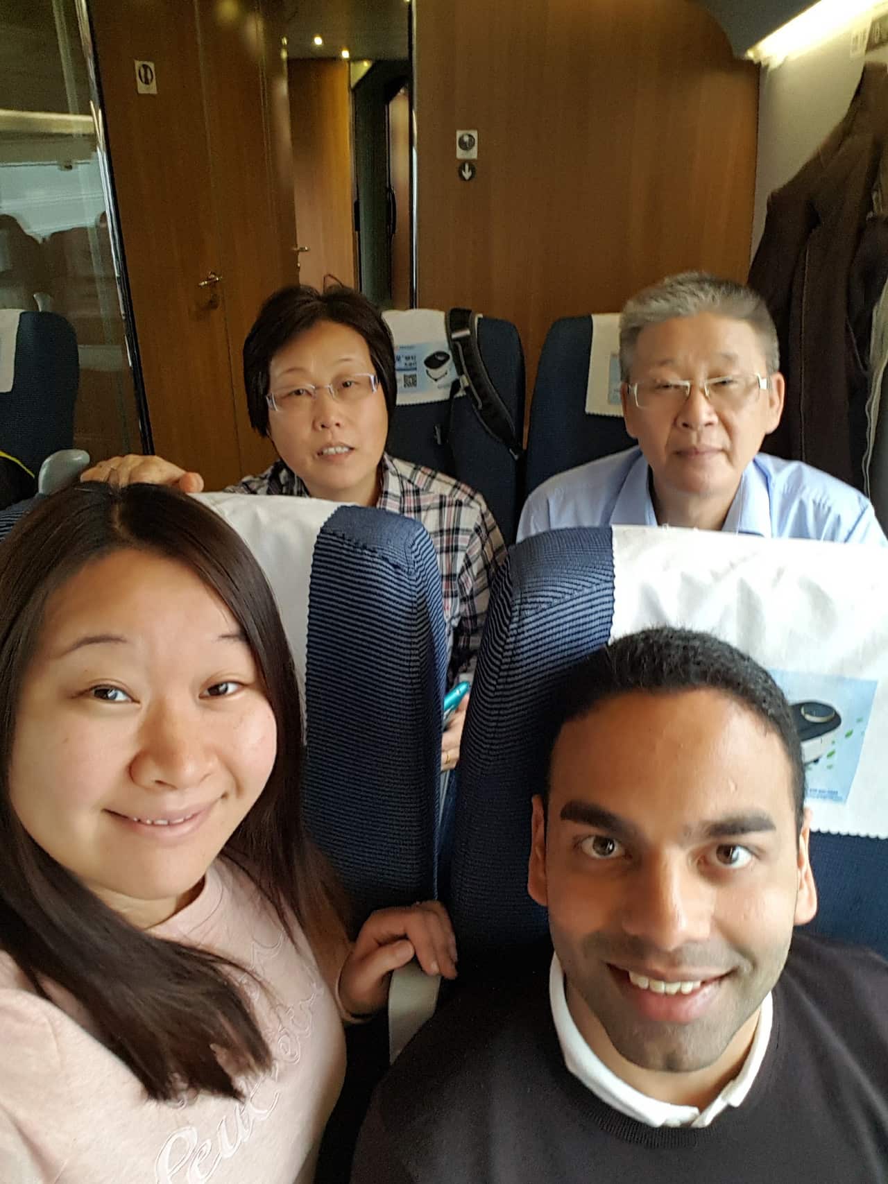 A selfie of Lalith on a bus sitting next to his wife Louise. Louise's parents sit in the row behind.  