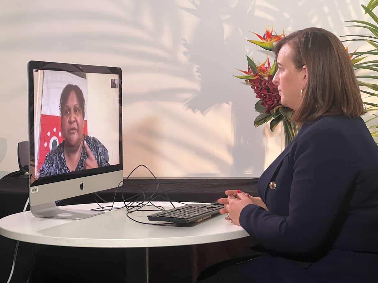 A woman sitting at a desk and conducting a video call on a computer