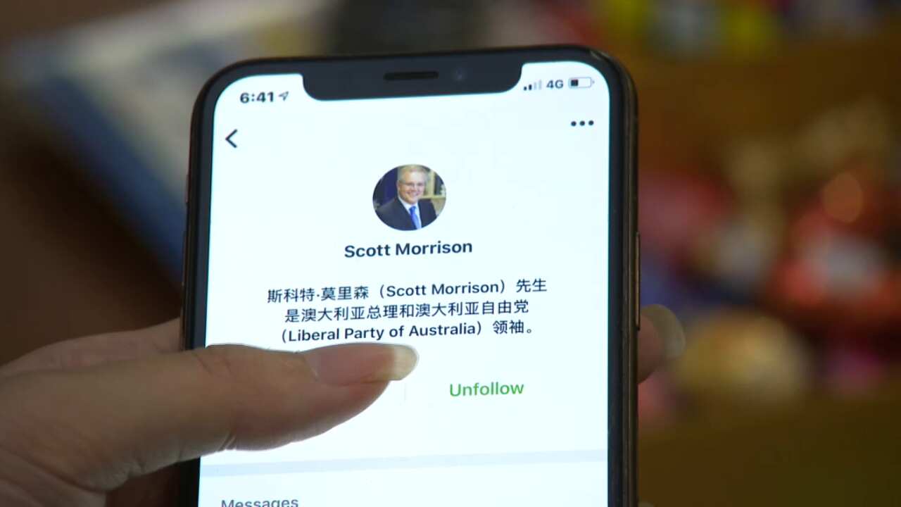 A hand holds a phone showing Scott Morrison's WeChat account.