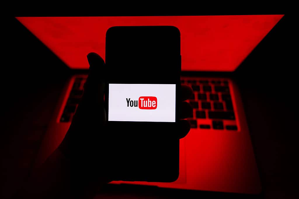 YouTube logo is displayed on a mobile phone screen