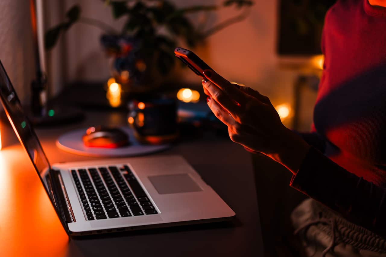 A phone displaying the LGBTIQ+ dating app Grindr with several men appearing on a grid layout.