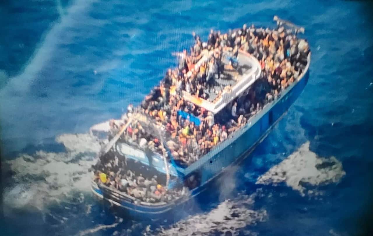 People cover practically every free stretch of deck on a battered fishing boat that later capsized and sank off southern Greece.