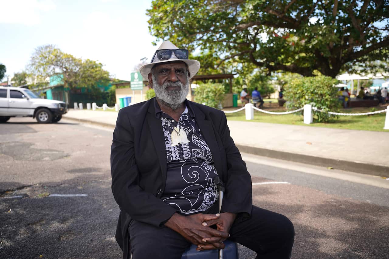 Un hombre se sienta en una silla en la calle.