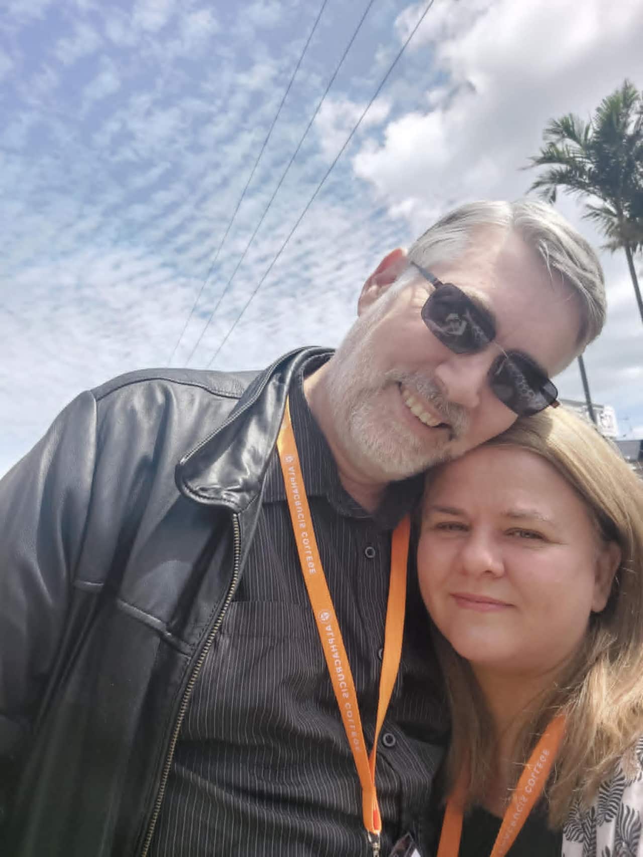 A couple embrace and smile at the camera.