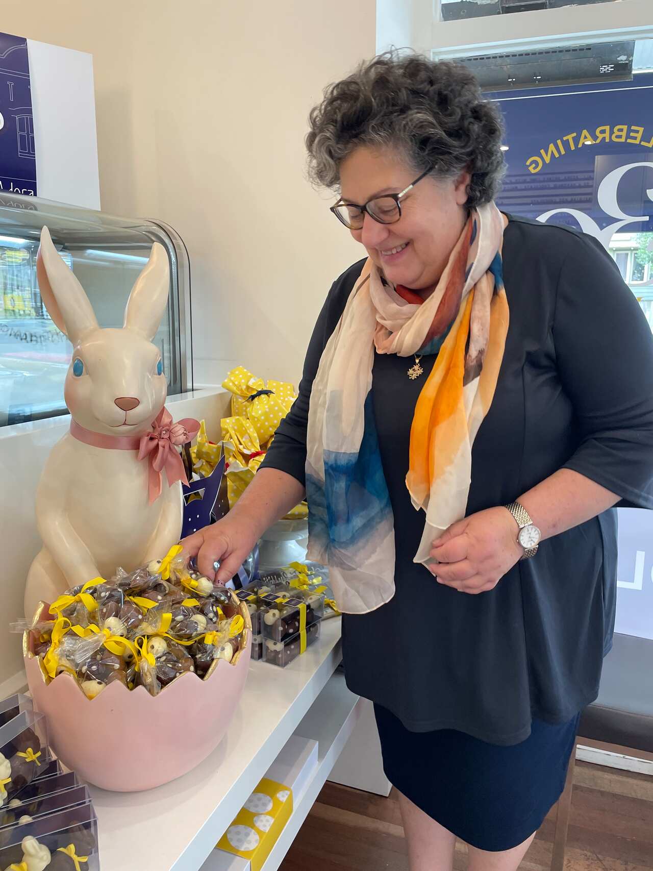 Katerina Stavropoulos standing next to an Adora Easter display.