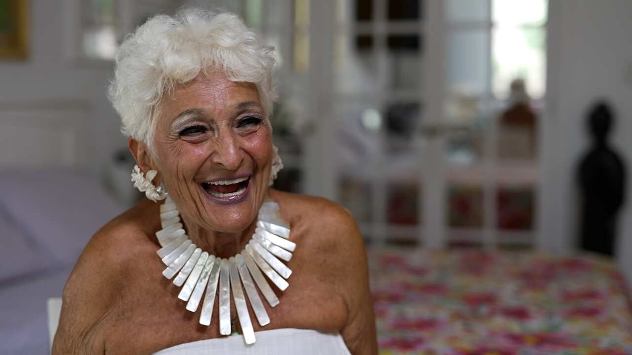 An older woman wearing a necklace.