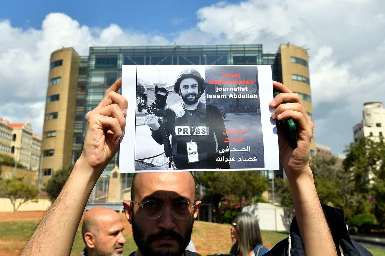 A man holds a poster of a journalist