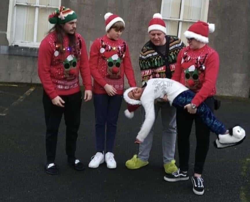 A family all wearing Christmas themed shirts.
