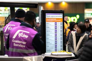 People look at an information board in a train station that reads "major delays".