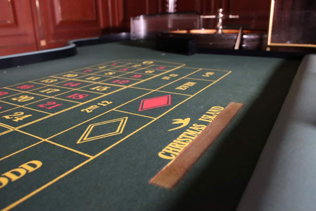 A gambling table in a dark room with Christmas Island font printed on it