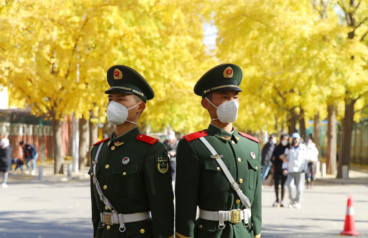Two uniformed Chinese police officers stand watch in a Beijing street.