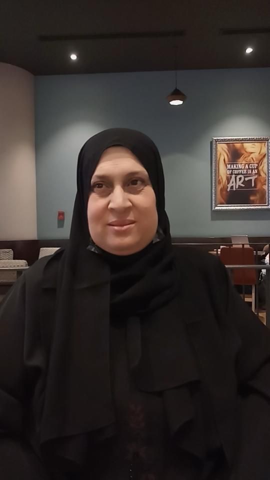 A woman in a burqa is sitting inside. 