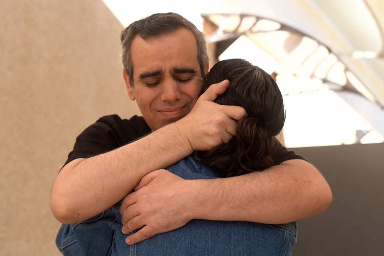 A man and a woman share an emotional embrace. 