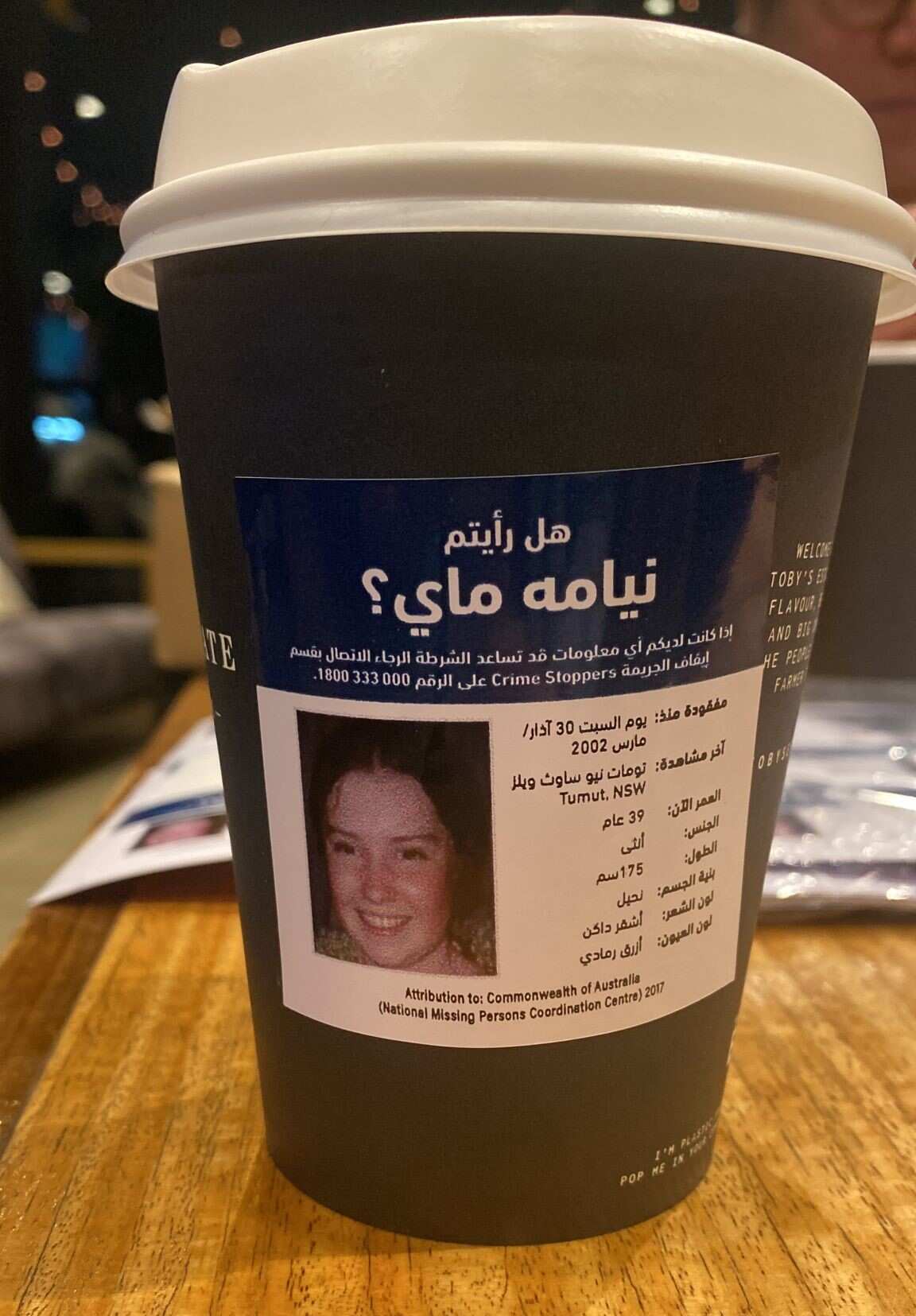Coffee cup with a missing persons profile on it, in Arabic. 