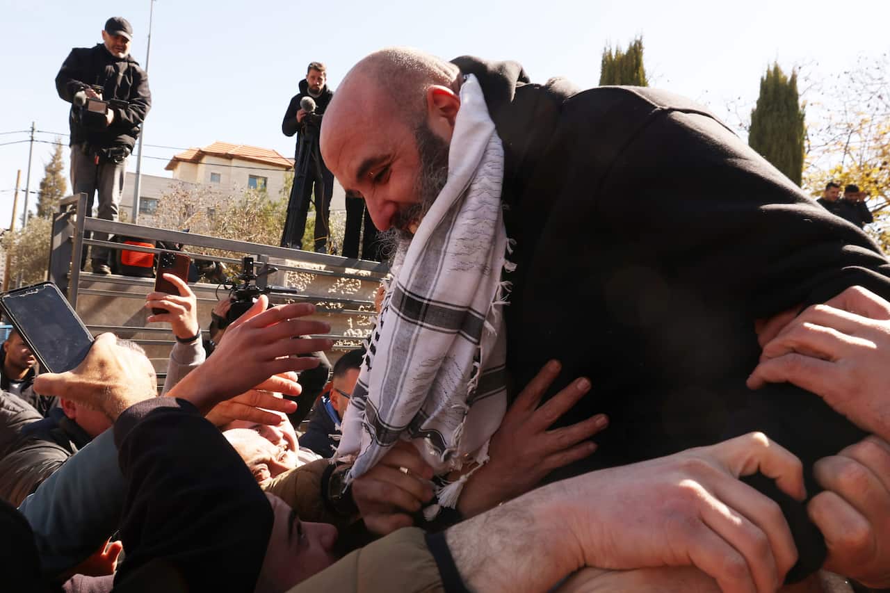 A Palestinian prisoner is surrounded by family after his release