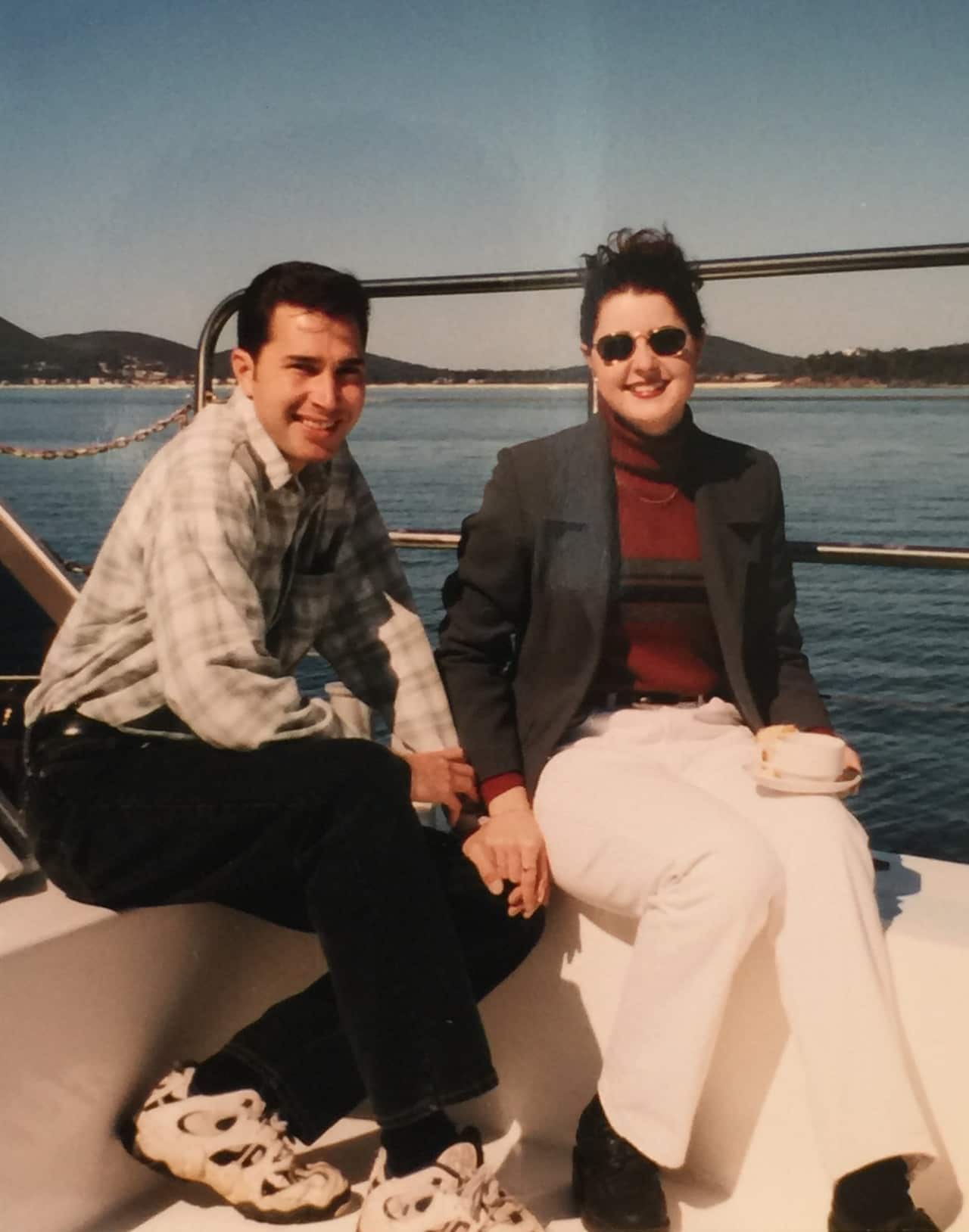 Sherrie and Sacha on a boat, holding hands.