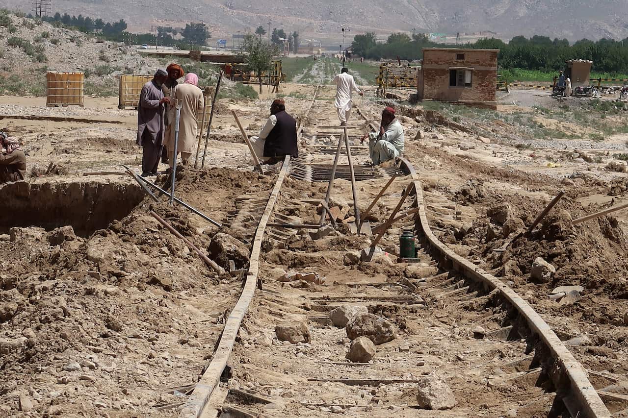 Workers repair a railway track that was damaged by floods following heavy rains on the outskirts of Quetta, Pakistan.