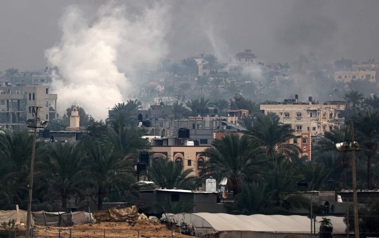 Buildings from a distance with smoke rising above. 