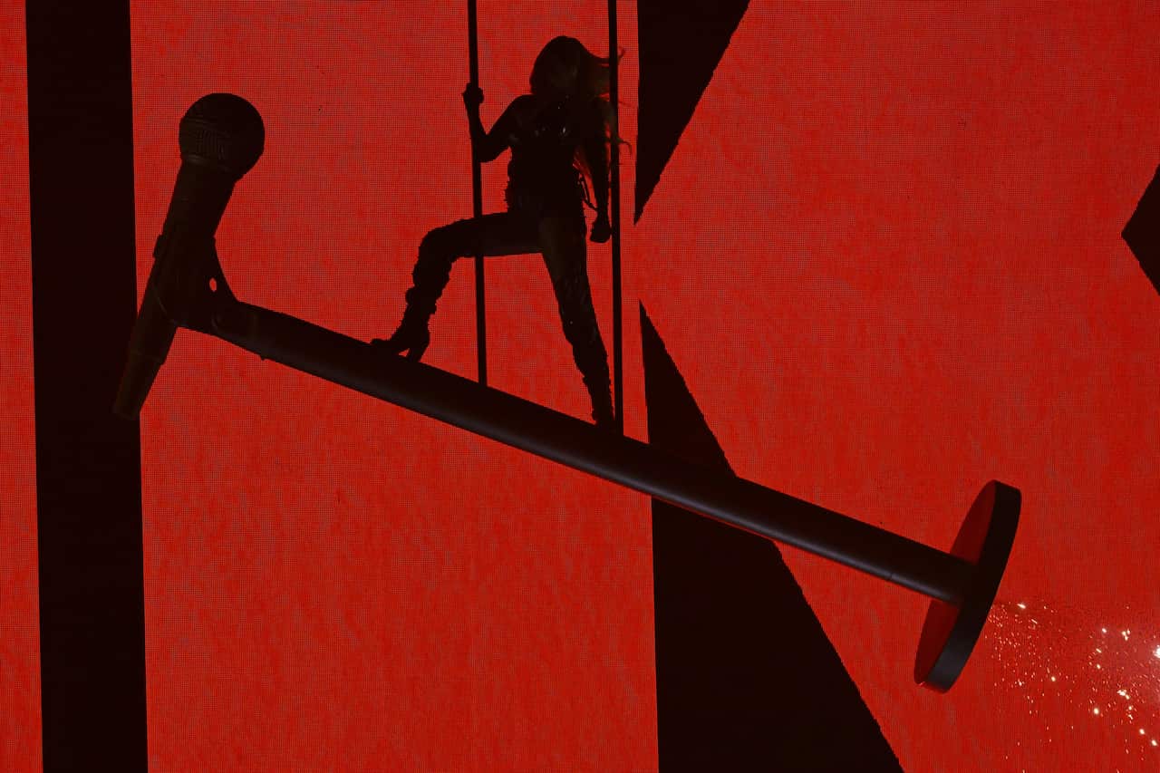 A silhouette of a woman on stage with a red backdrop