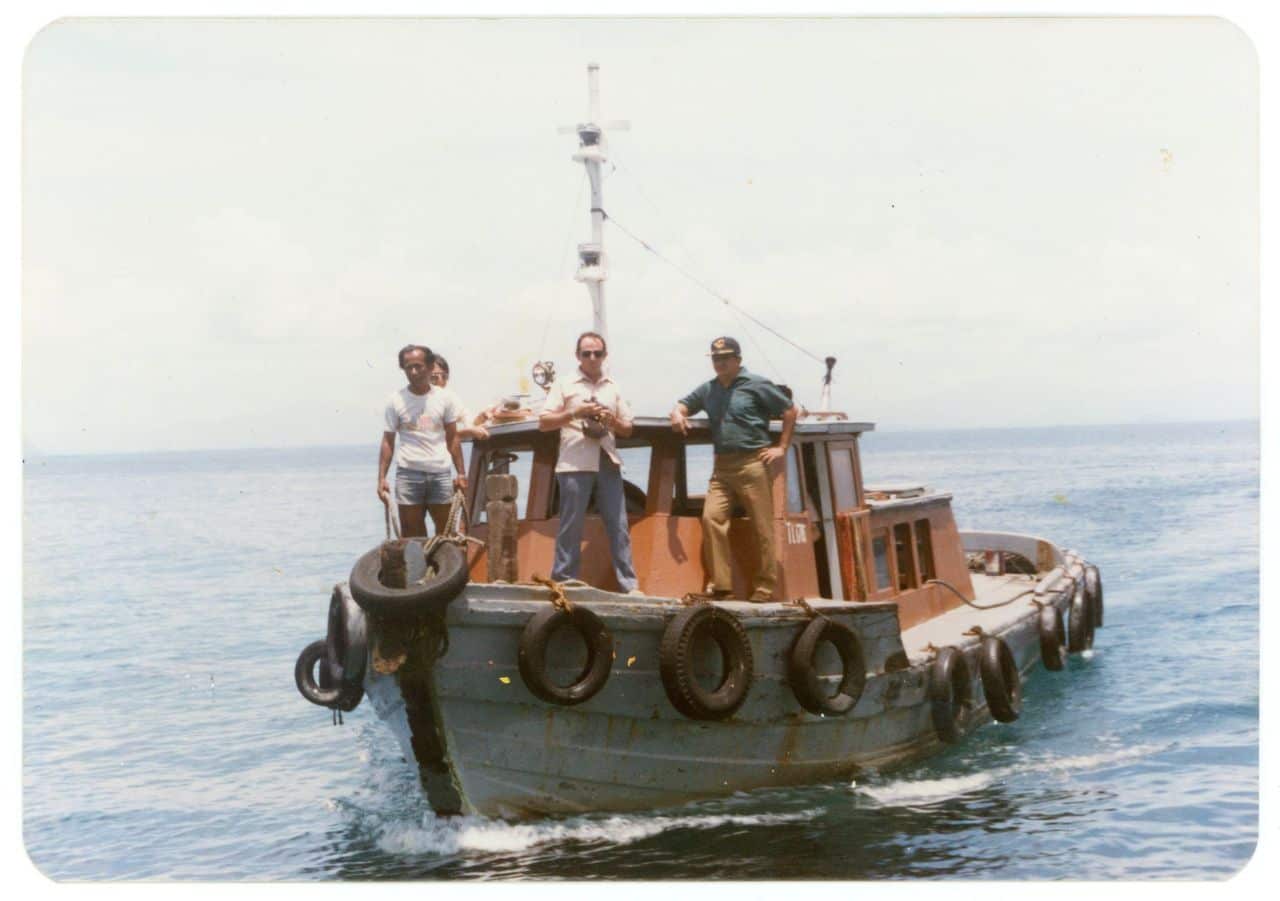 A photo taken in 1981 showing three men standing on a Malaysian government boat used to transport Vietnamese refugees.
