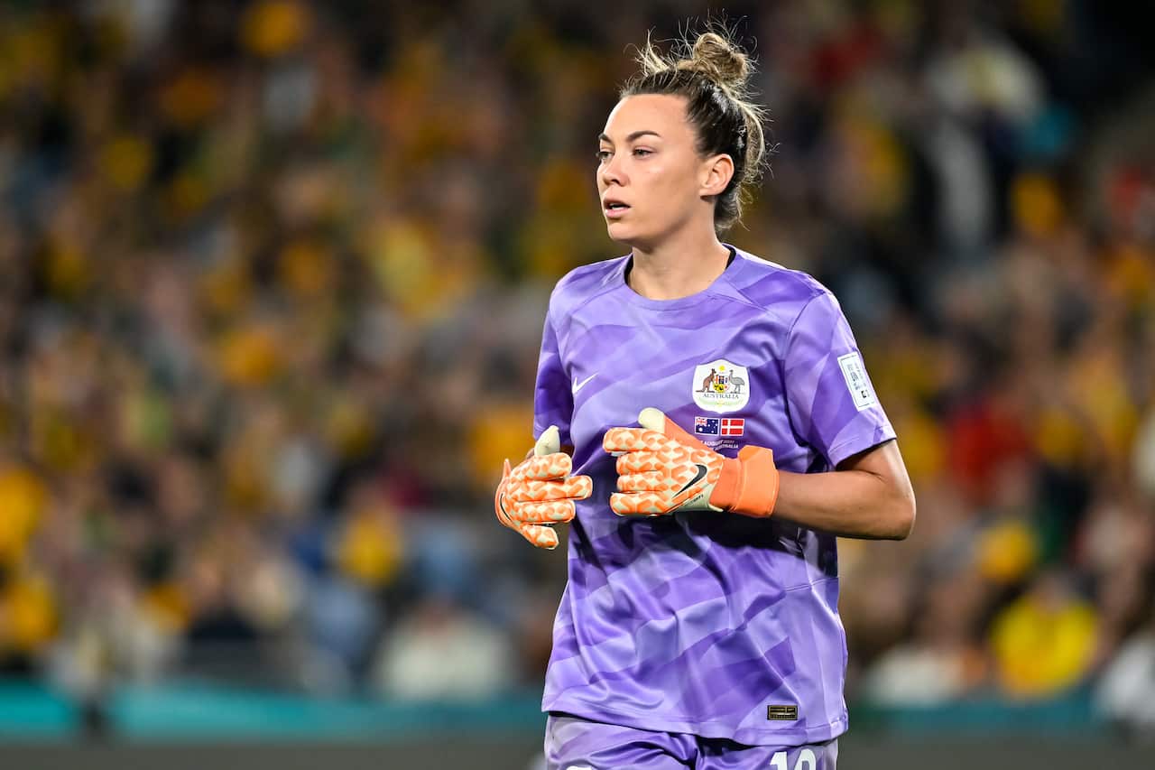 A woman in a purple shirt and orange gloves