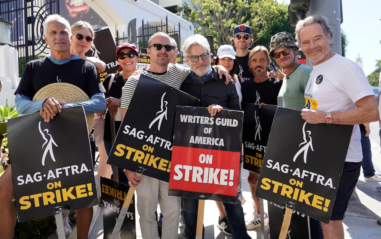 A group of people holding posters and smiling.