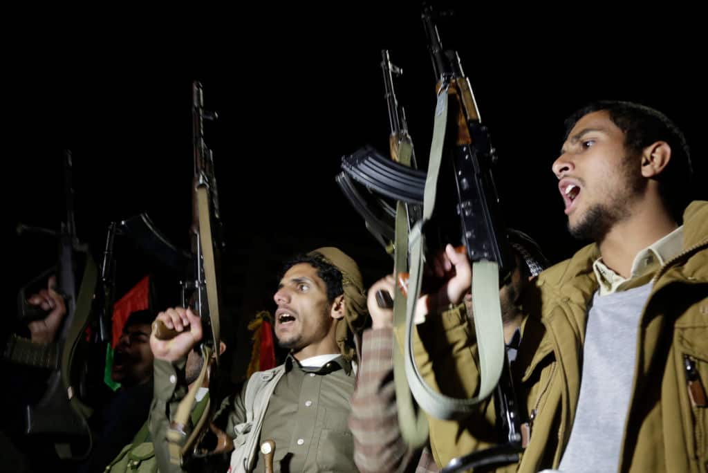 Two men at night holding up guns and shouting
