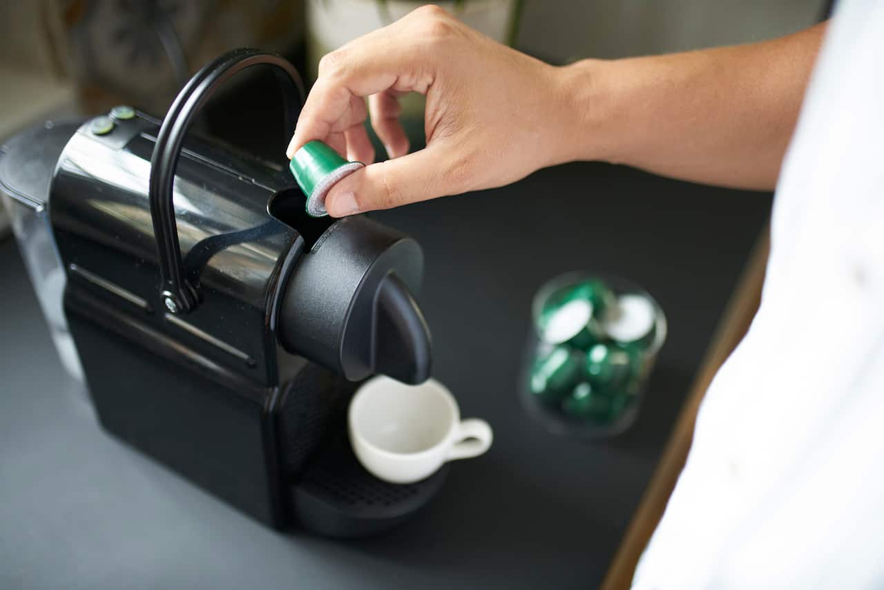 Man making an espresso with a capsules coffee maker