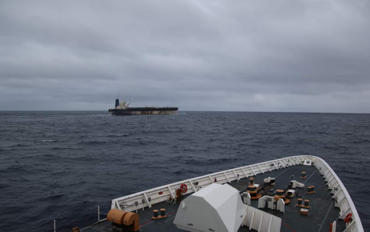 An image of a tanker in the ocean, taken from a vantage point on another ship nearby.