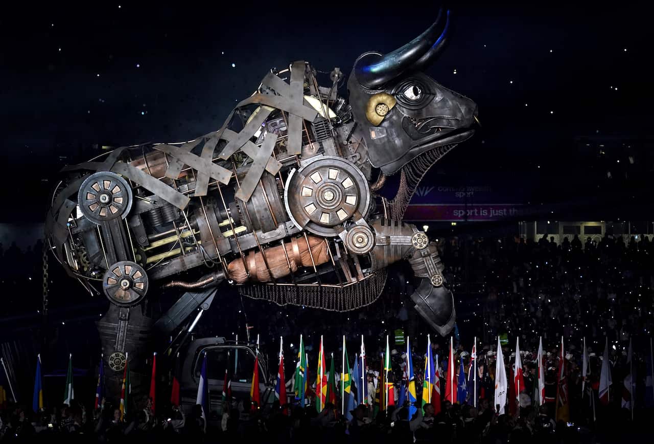 A huge industrial-looking bull stands on two legs. Various flags can be seen underneath it. 