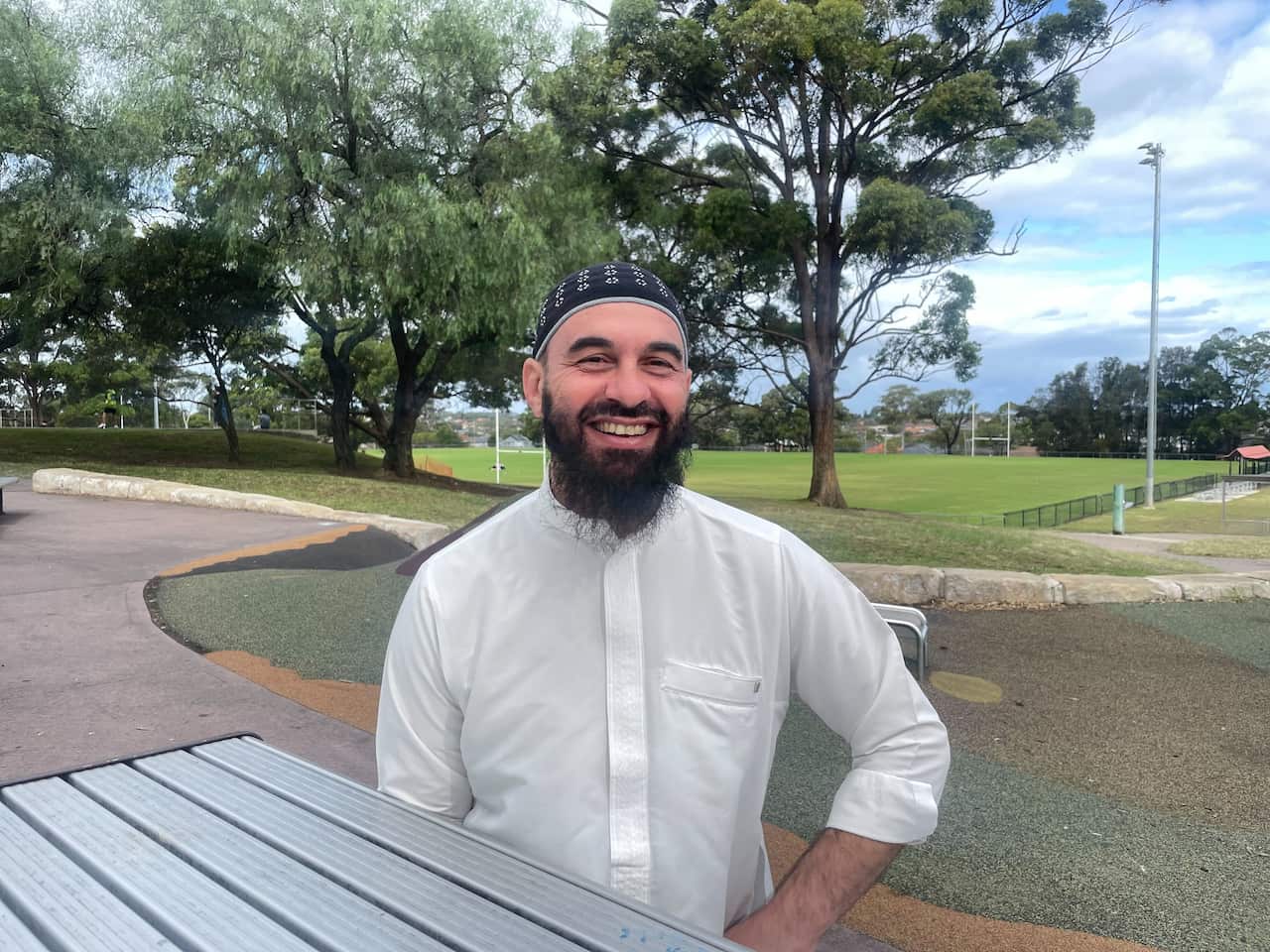 A man in a white shirt and wearing traditional headwear. 