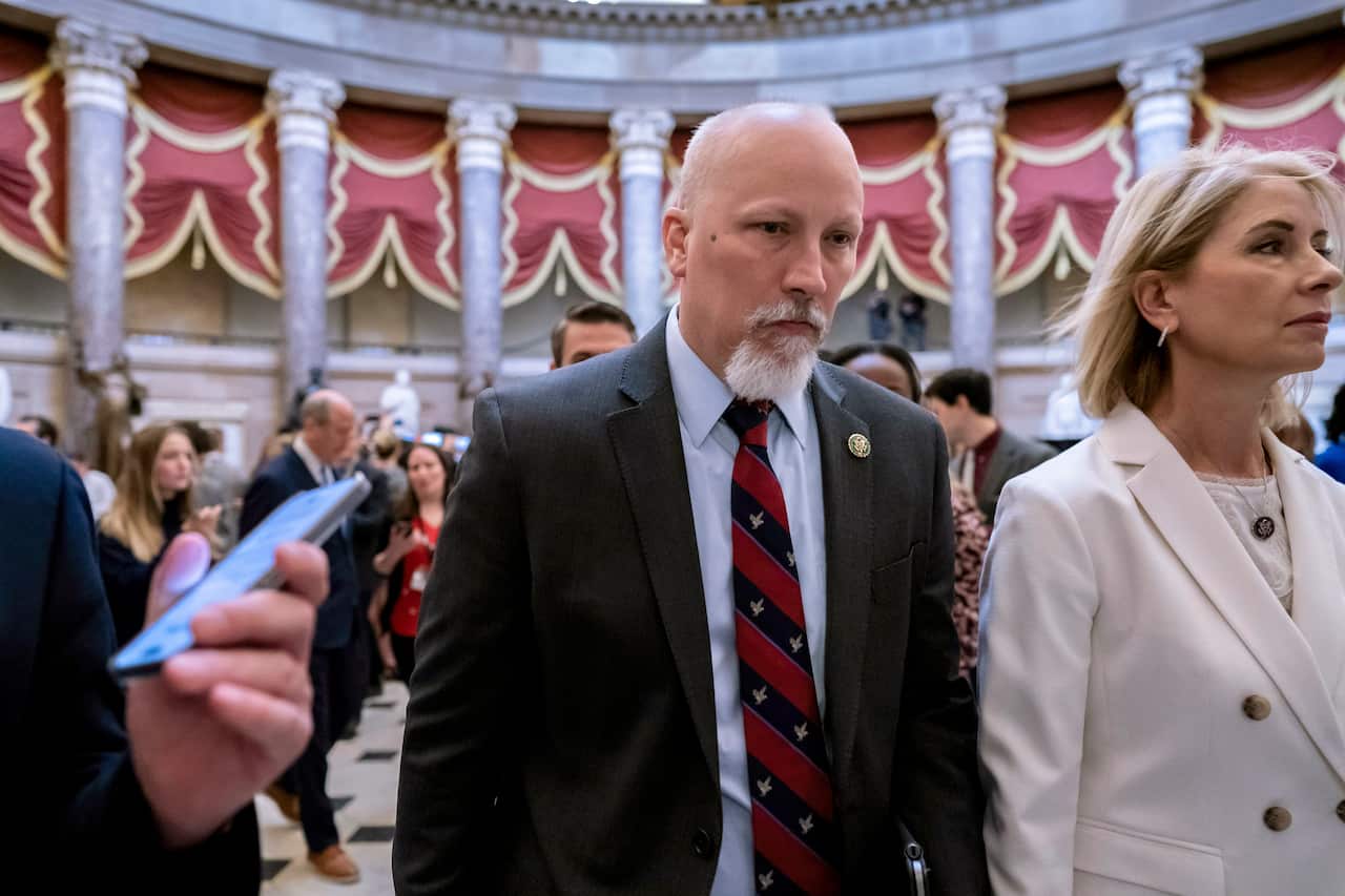 A man wearing a suit and tie walks next to a woman.