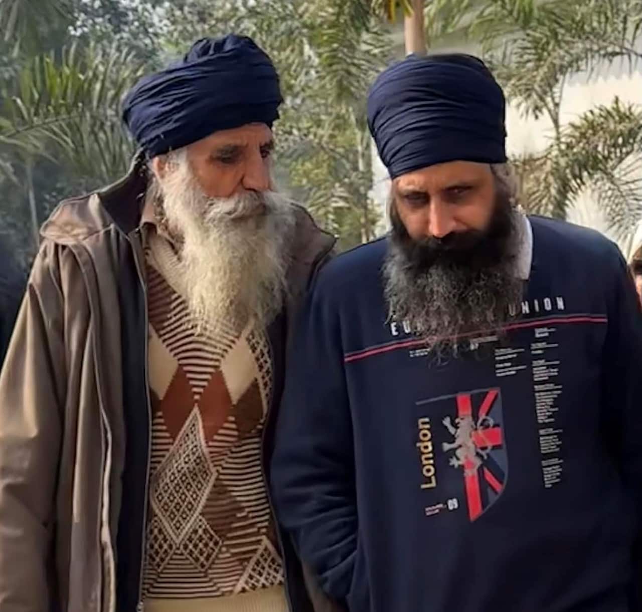 Two men walking next to each other outside.