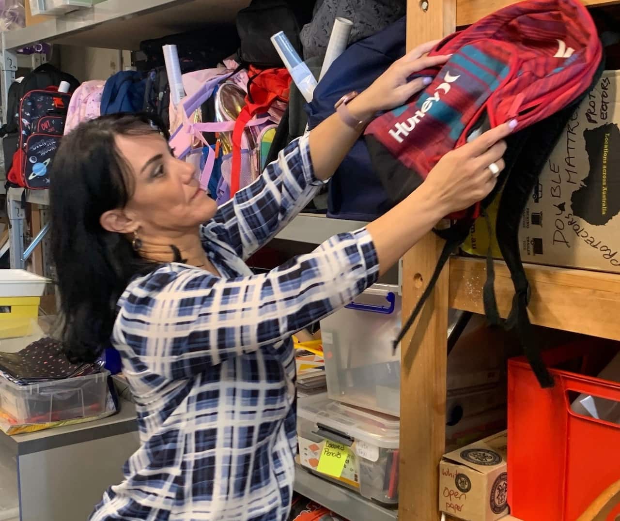Manuela placing a donated backpack on a shelf