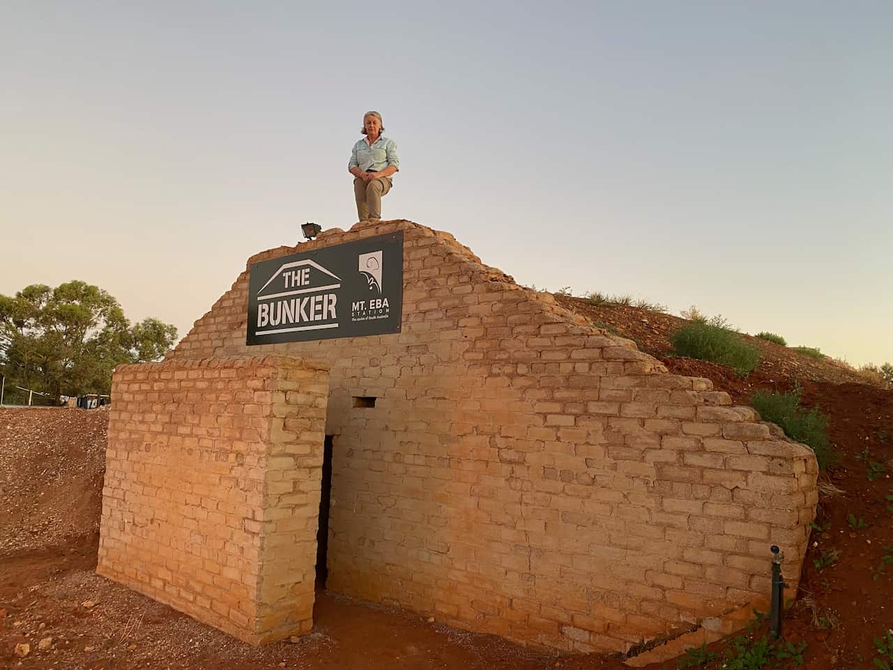 Woman standing on top of disused bomb shelter.