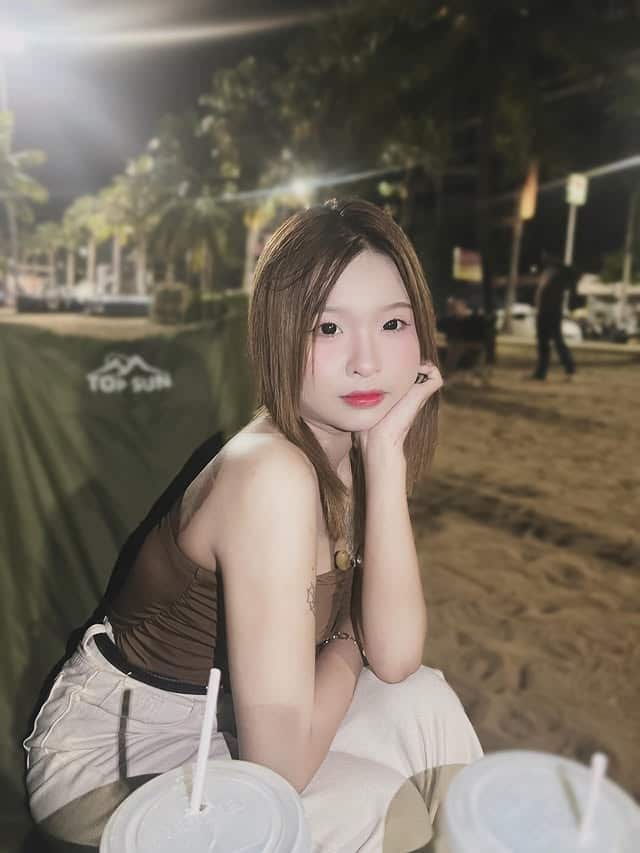 A woman posing for a photo while sitting on a chair outside.