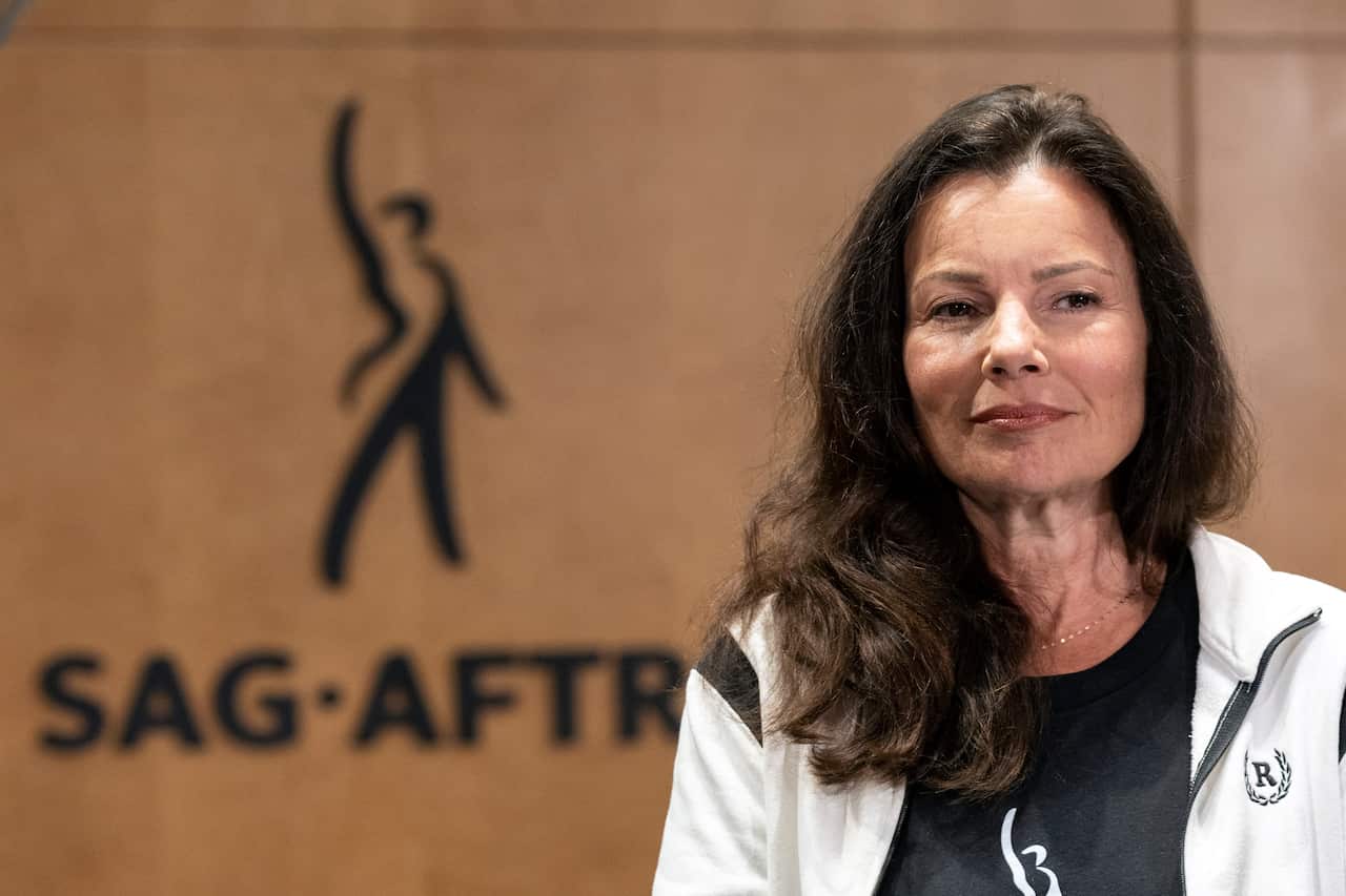Actor Fran Drescher standing in front of a sign that reads SAG-AFTRA.