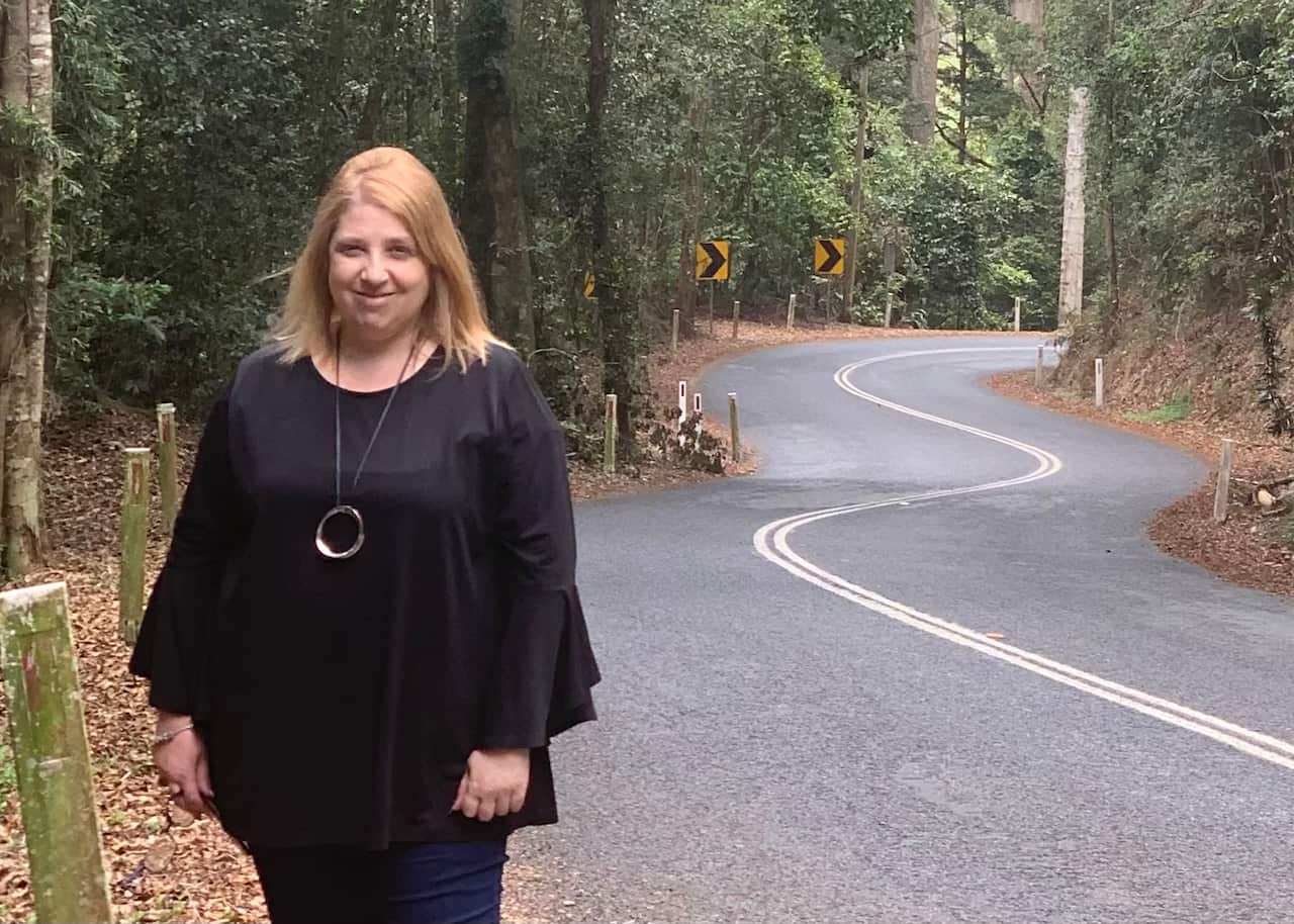 Private driver and uber driver Rosalina Pirozzi posing on the side of a windy highway on a road trip