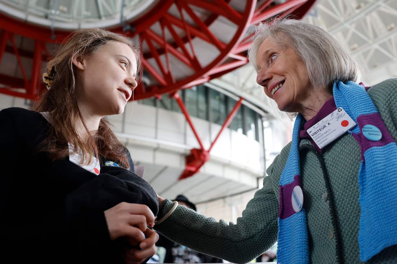An older women from Switzerland and Greta Thunberg smiling at eachother