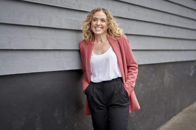 A woman standing next to a wall