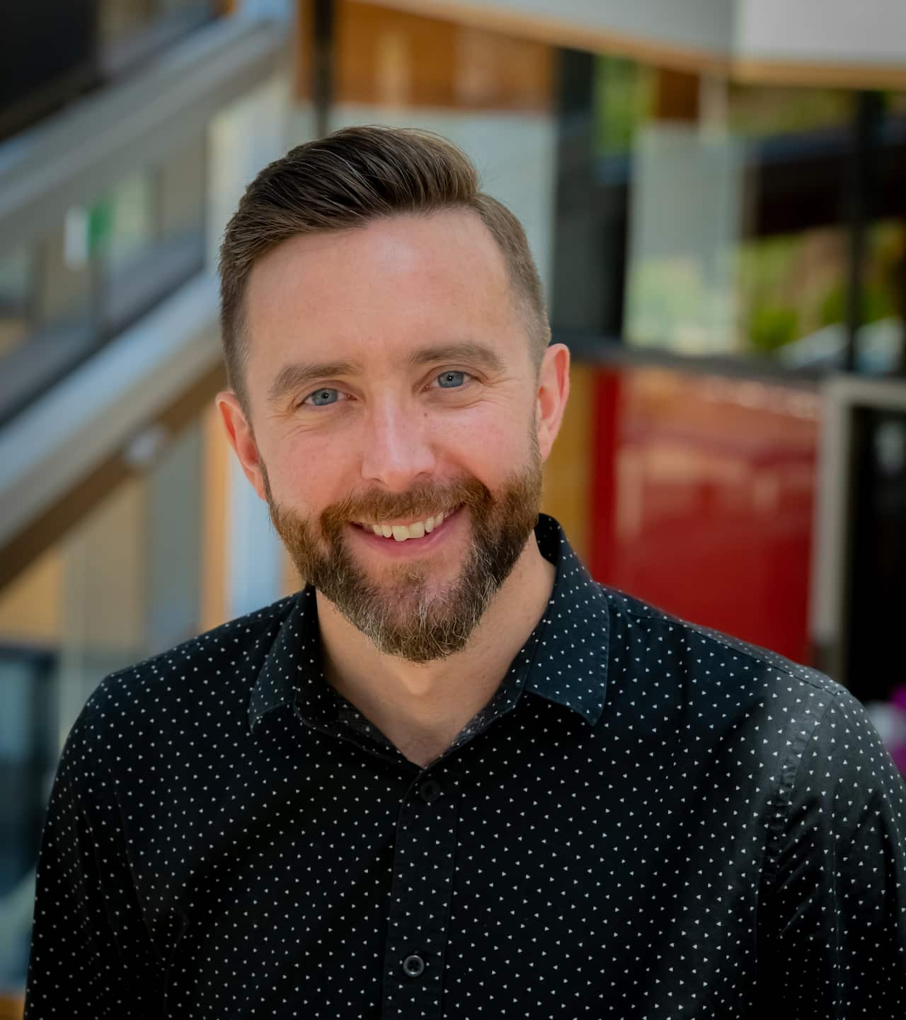 A man with a beard wearing a long sleeved shirt.