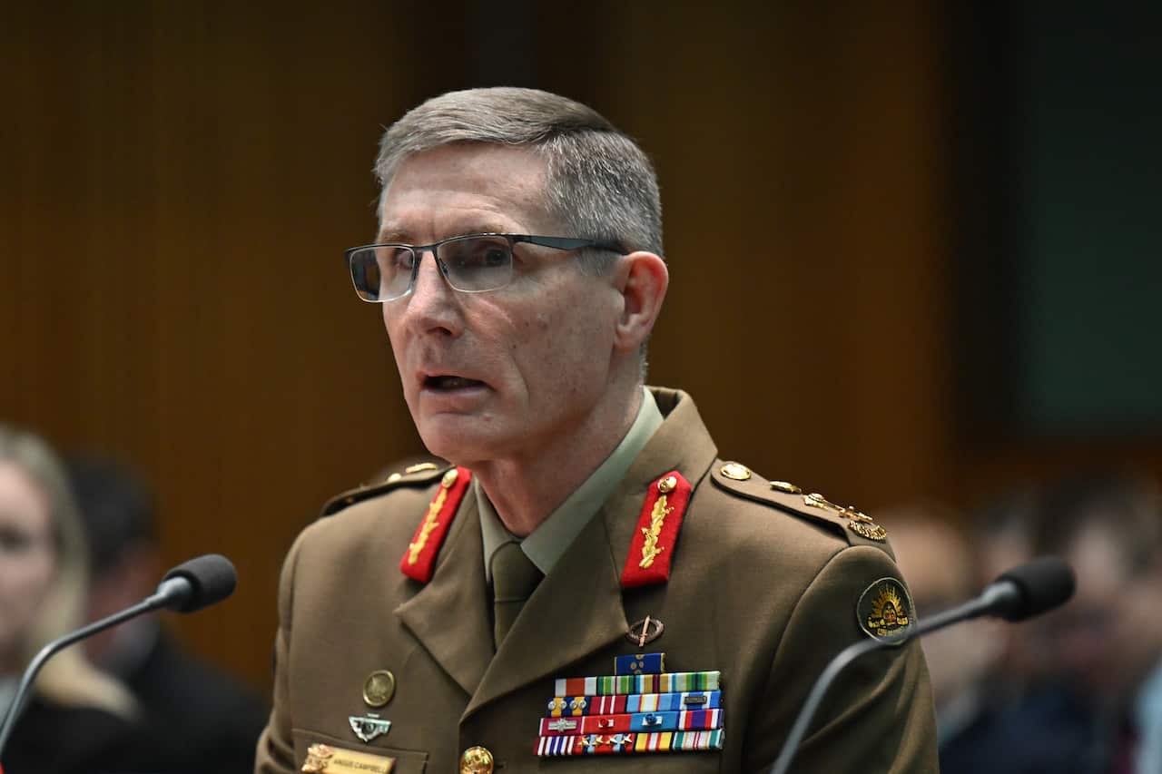A military personnel wearing glasses speaks at a senate hearing