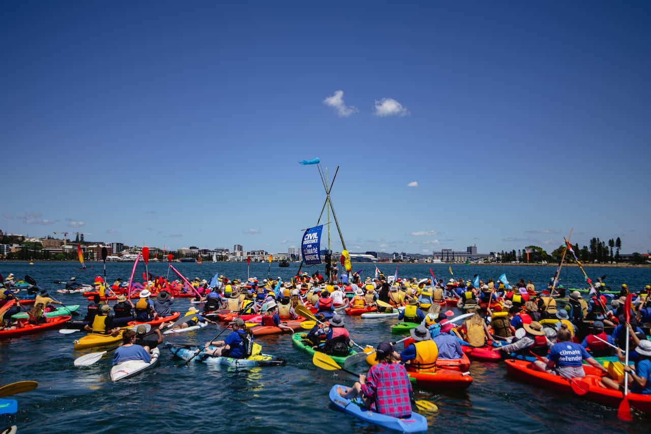 Dozens of colourful kayaks in the water outside the port of Newcastle.