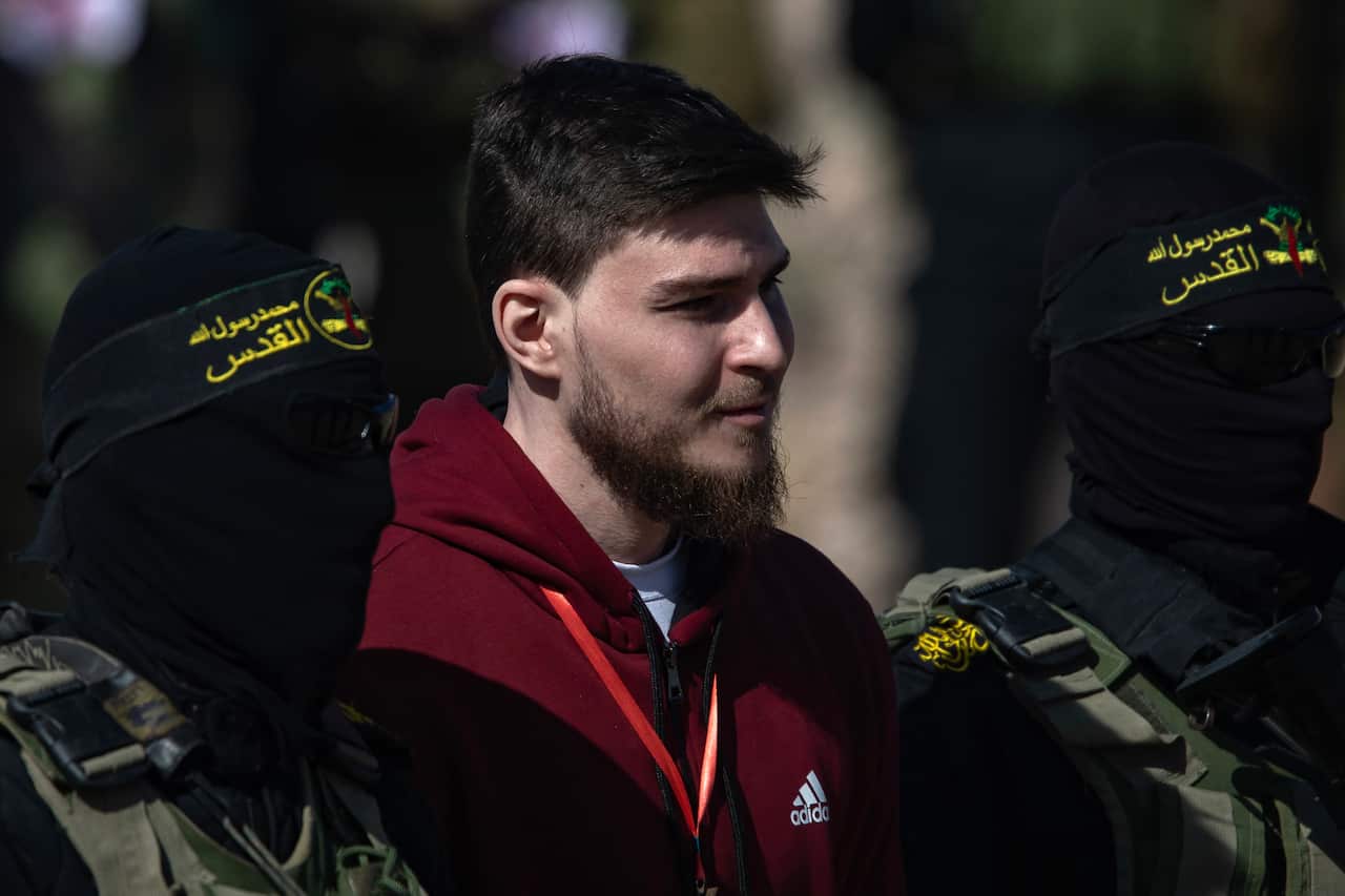A Russian-Israeli hostage is escorted by militants after his release in Gaza. 