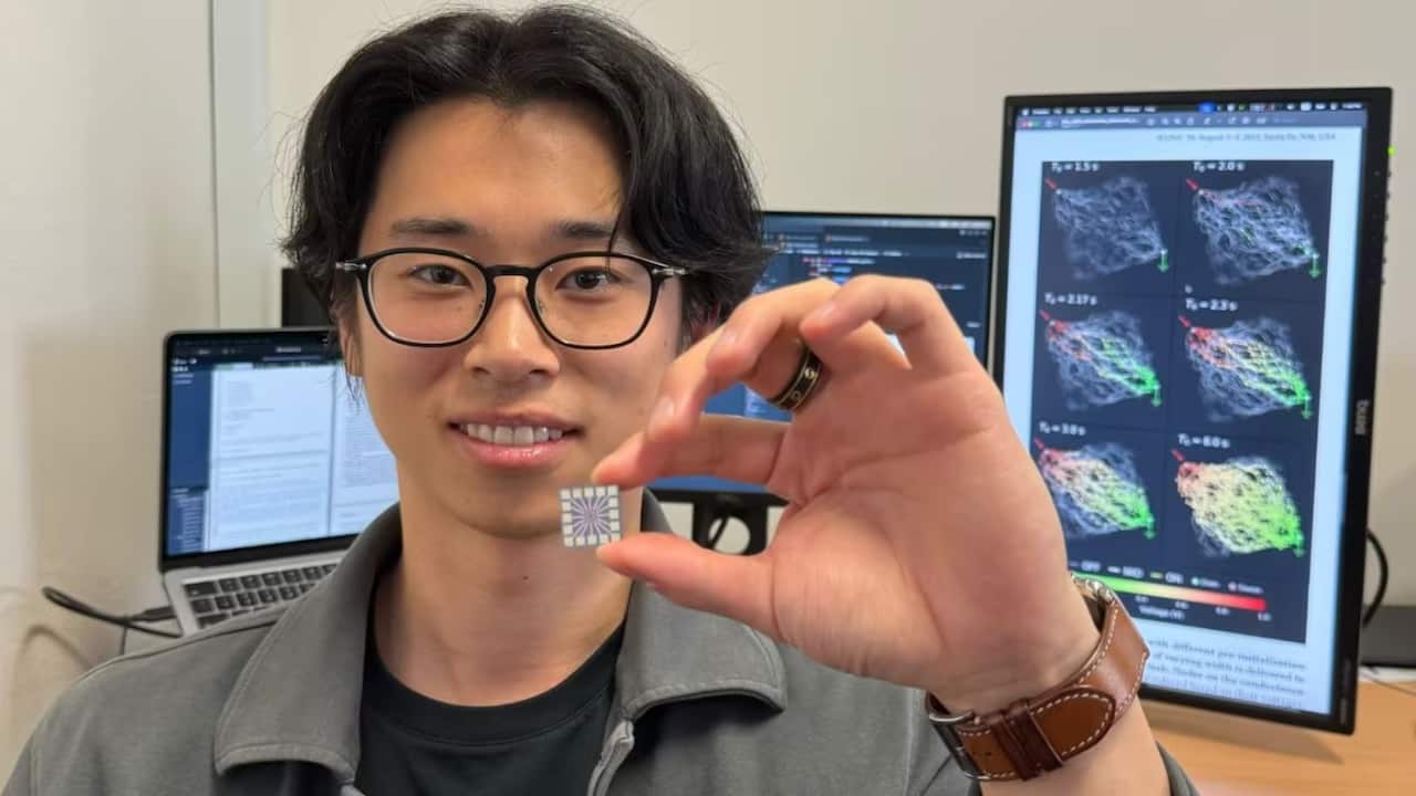 Lead author and PhD student Ruomin Zhu holding the chip that manages the neural network at its centre.JPG