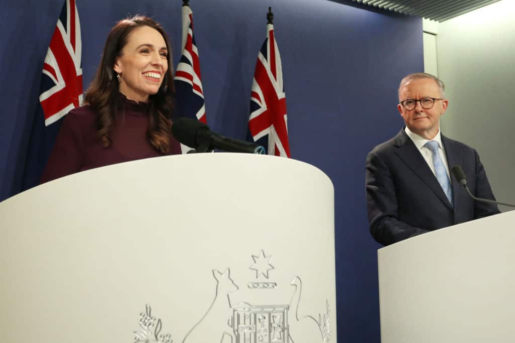  Jacinda Ardern and Anthony Albanese standing behind lecterns in a room 