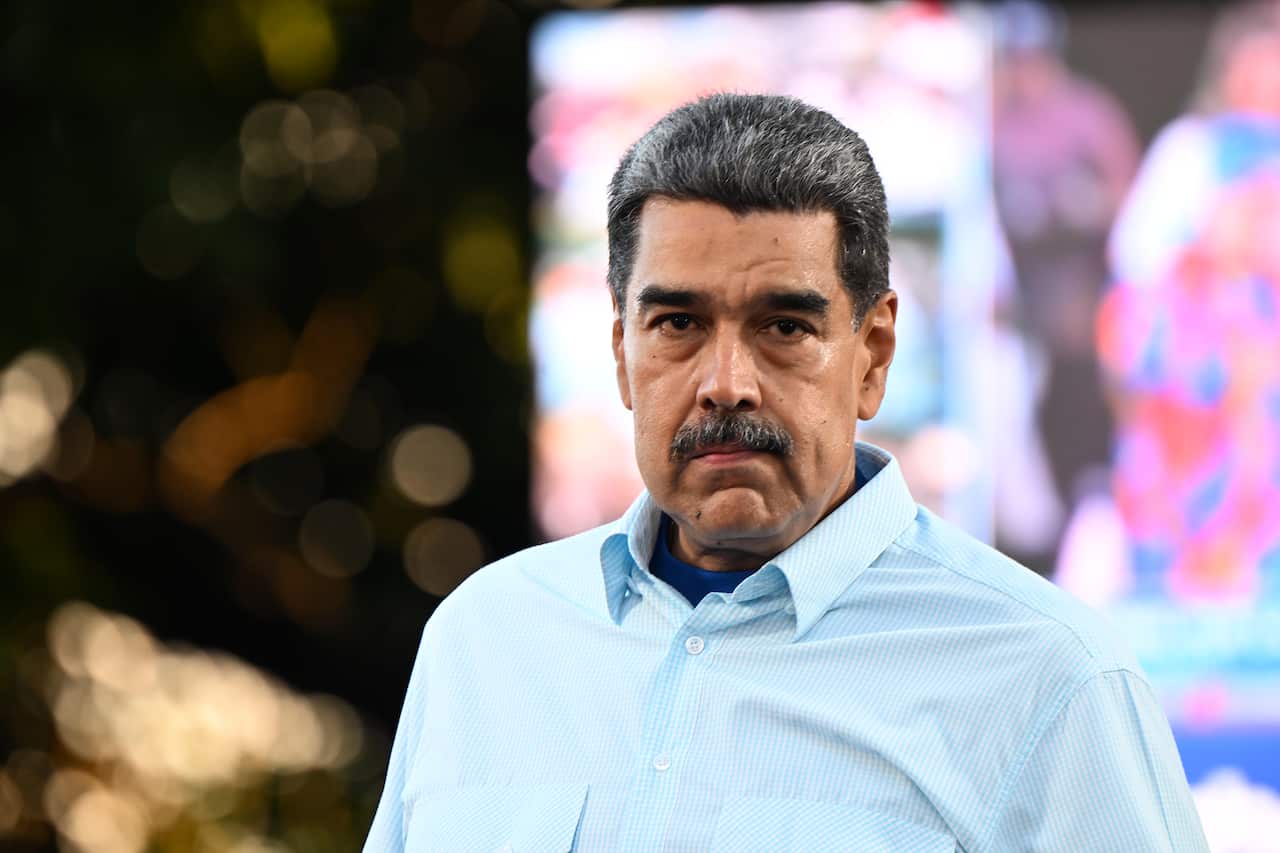 Nicolas Maduro, wearing a blue shirt.