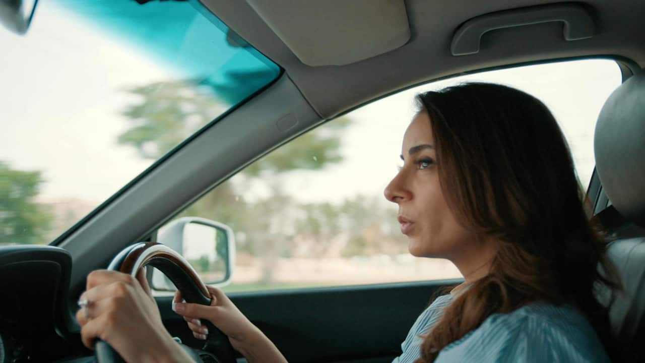 A woman drives a car. 